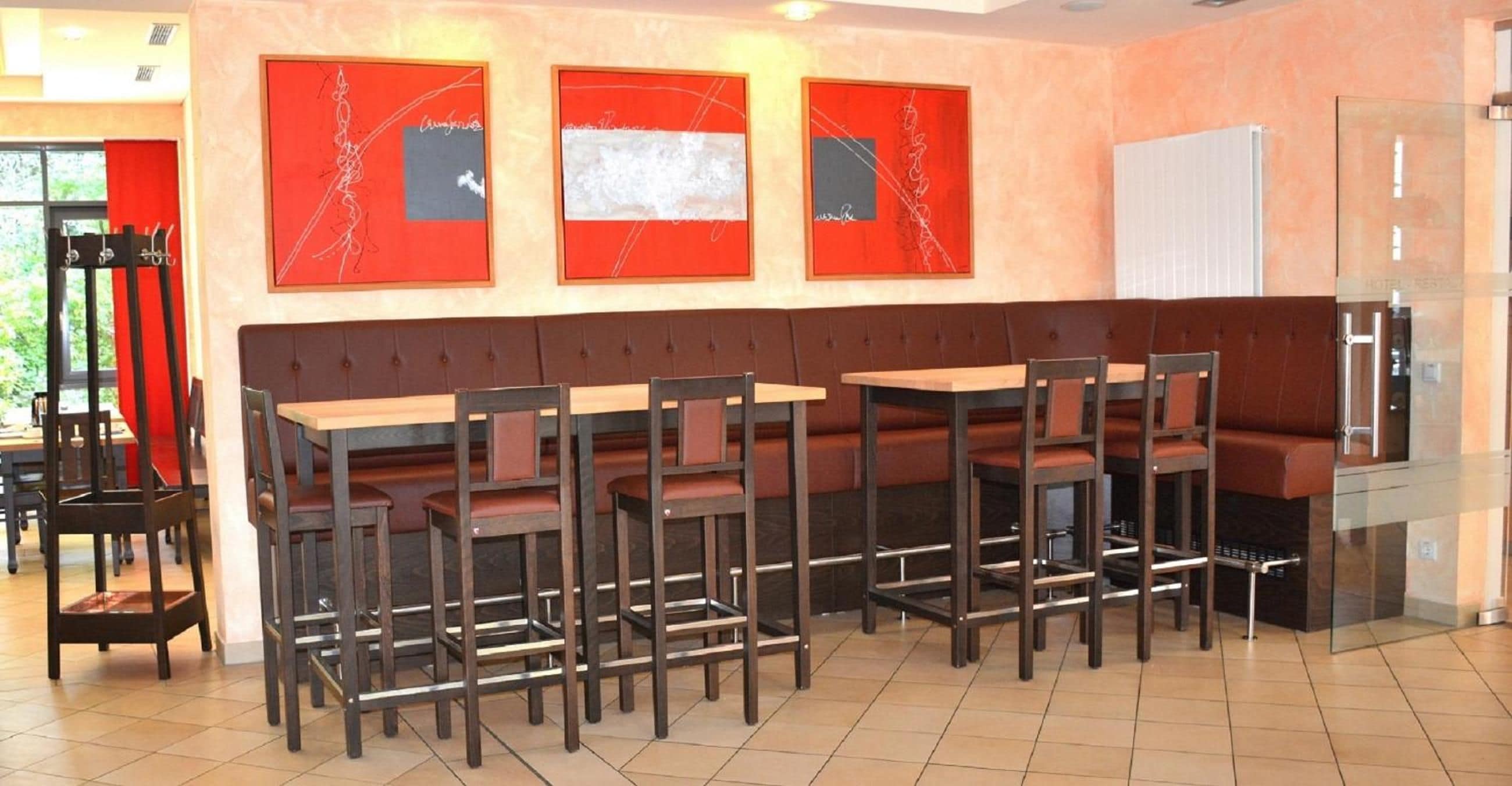 A restaurant with a long counter and multiple seating options.