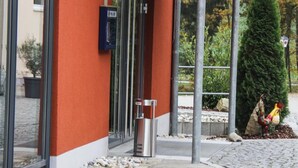 A building with a red exterior, large glass windows, and a metal entrance canopy. - Landhotel Neunburg (Neunburg vorm Wald)