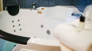 A white hot tub with multiple jets, a control panel, and a small label.