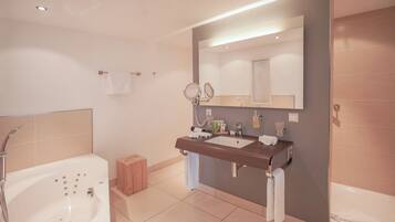 A modern bathroom with a bathtub, a vanity with a mirror, and a shower area.