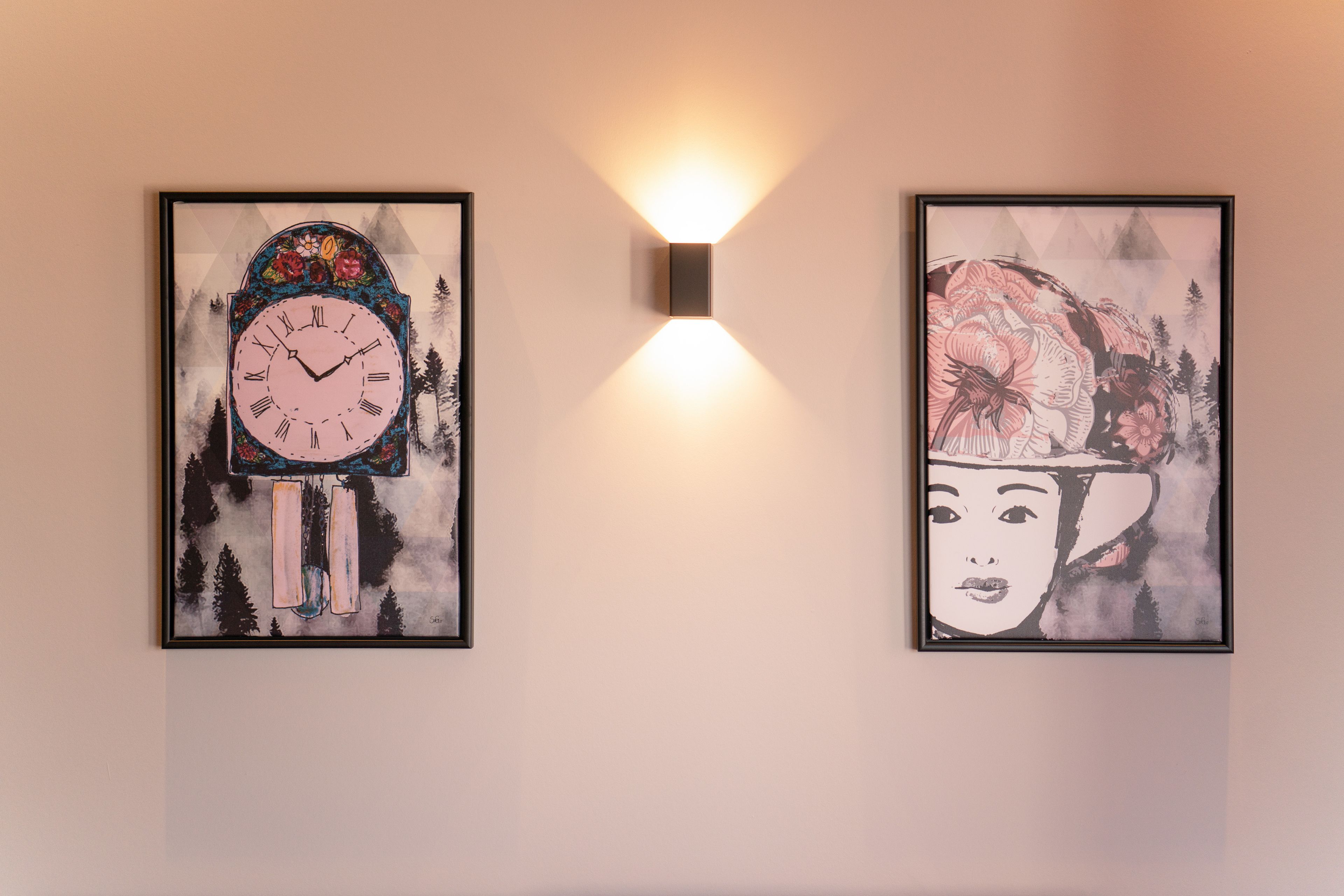 Two framed artworks on a wall, one depicting a clock and the other a floral design.
