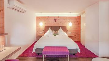 Un dormitorio moderno con una cama grande, paneles de madera y lámparas colgantes.