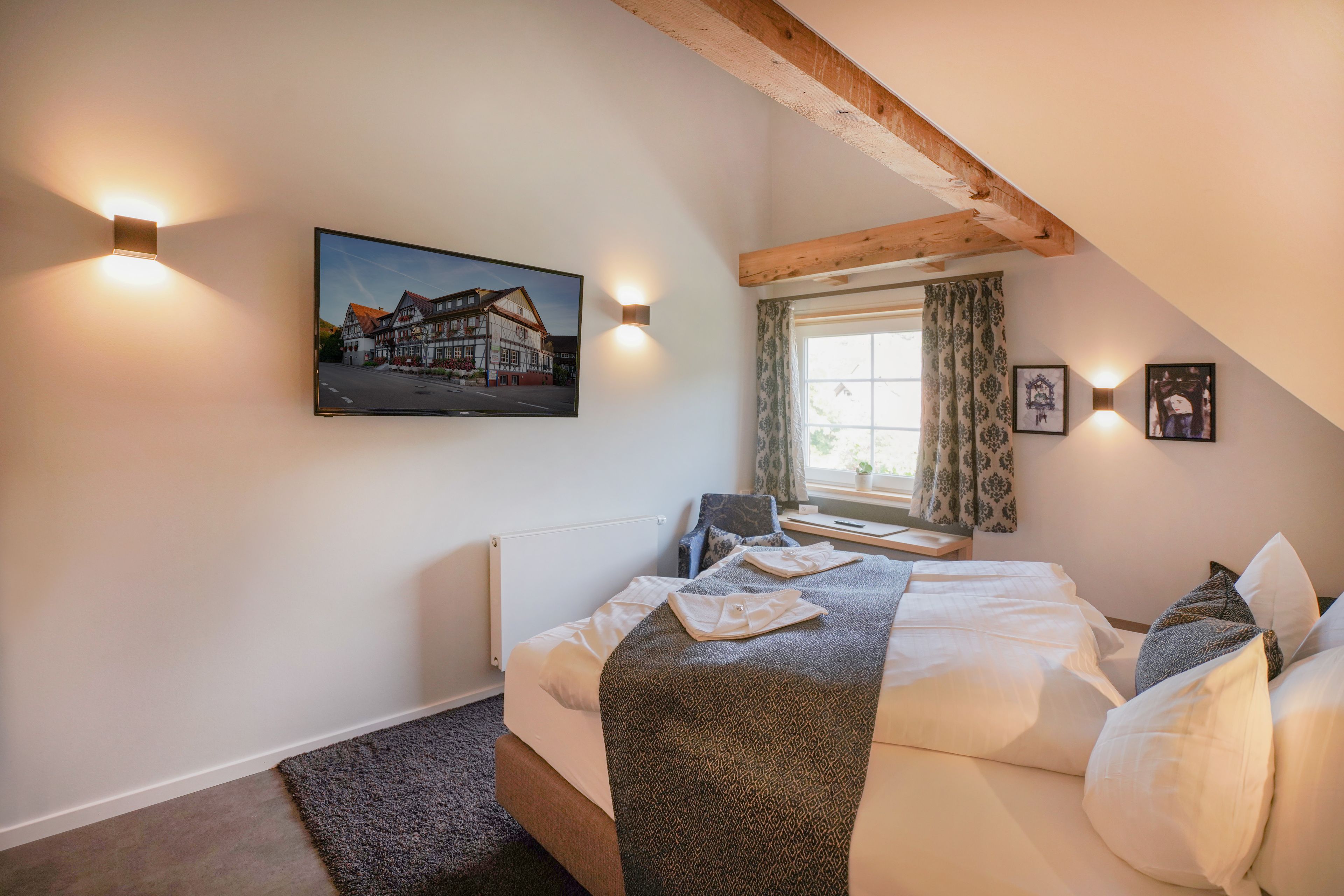 A cozy bedroom with a bed, a painting, and a window with curtains.