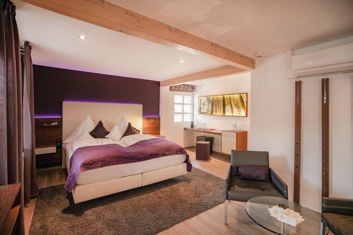 Un dormitorio moderno con una cama, un escritorio y una silla.
