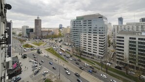 A busy urban intersection with modern buildings, a roundabout, and multiple lanes of traffic. - Art&Apart (Warsaw)