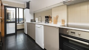 A modern kitchen with a dishwasher, oven, and a coffee maker. - LV Premier Marques - MQ2 (Porto)