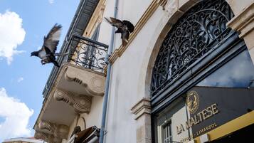 A building facade with ornate ironwork balconies and a sign reading "LA MALTISE".