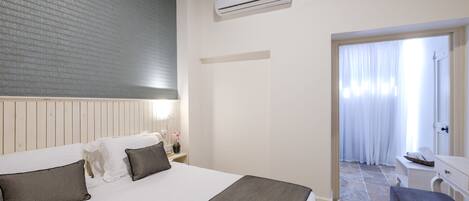 Une chambre d’hôtel équipée d’un lit, d’une table de chevet et d’un appareil de climatisation.