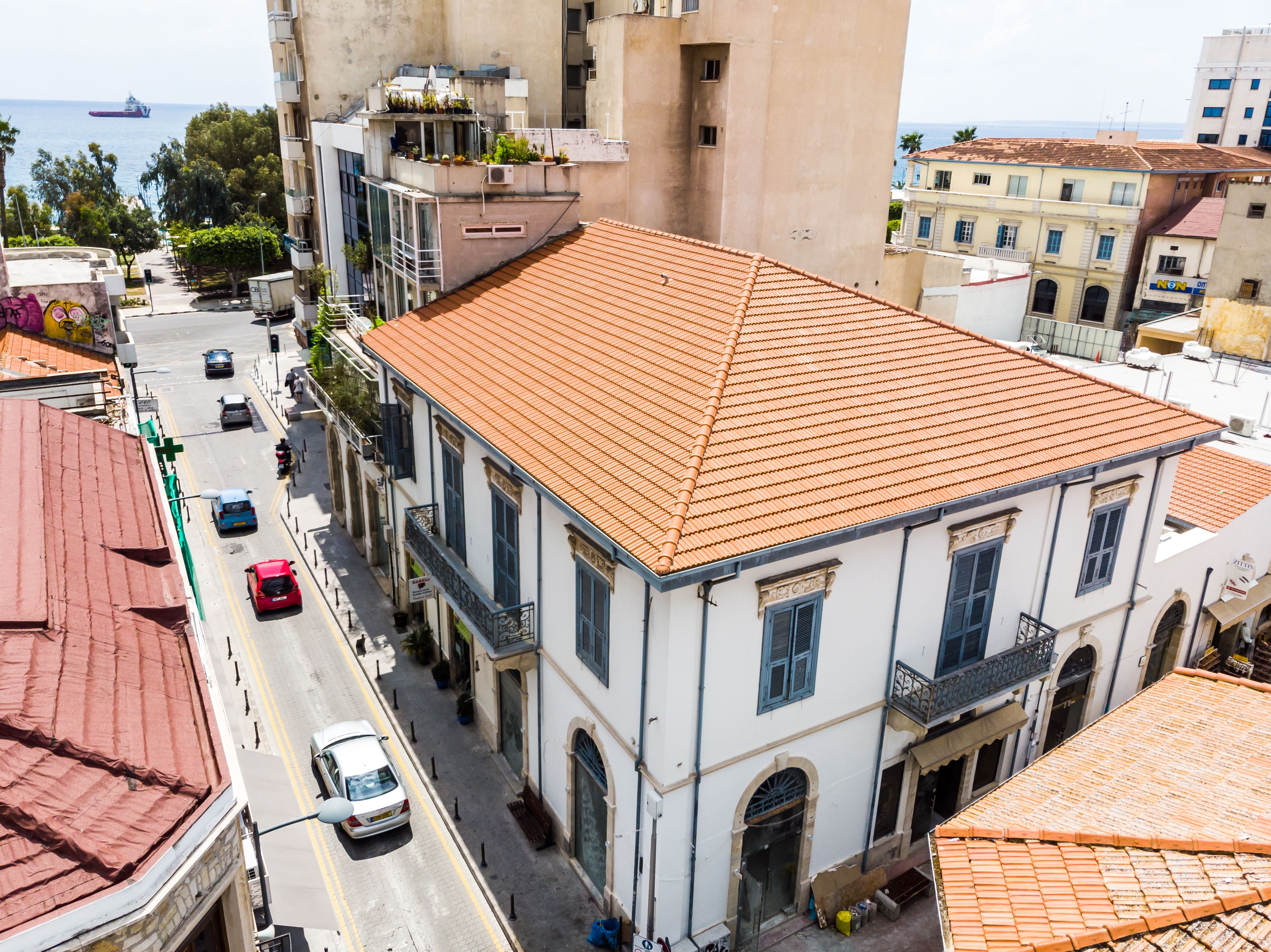 A building with a red-tiled roof, white walls, and a balcony.