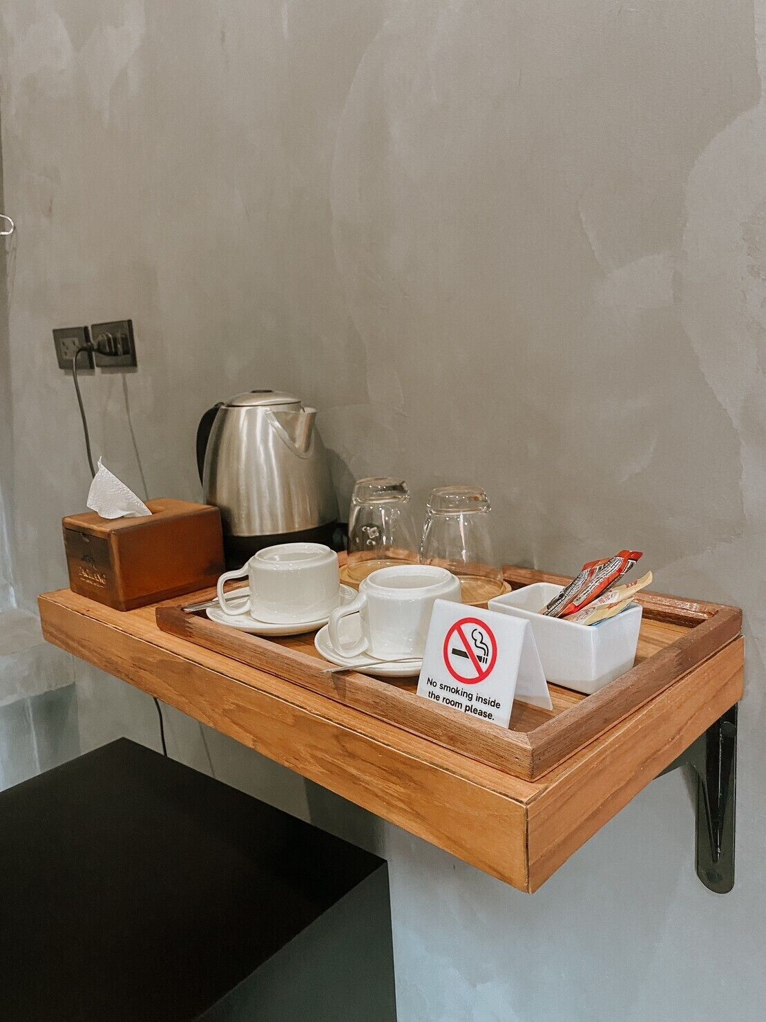 Een ontbijfwagen met koffiekopjes, een theepot, suikerzakjes en een rookvrij bordje.