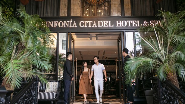 L’entrée de l’hôtel et du spa Sinfonía Citadel, avec ses palmiers et son lustre.