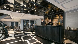 A lobby with a check-in counter, seating area, and a staircase. - La Sinfonia Citadel hotel and Spa (Hanoi)