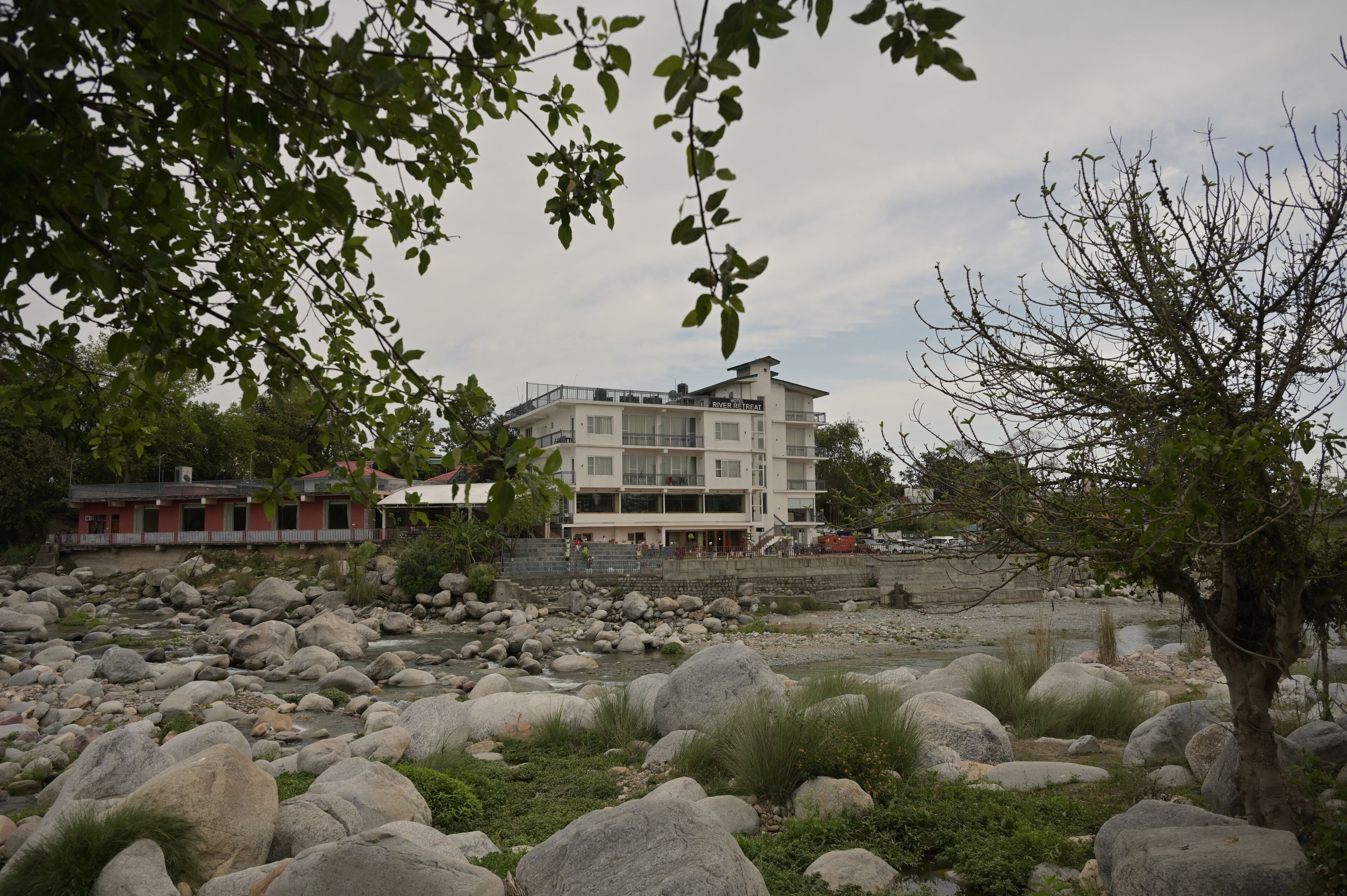 A riverside hotel with a modern design, featuring large windows and a flat roof.