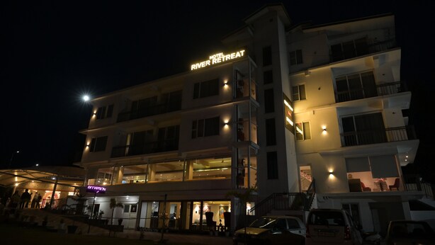 Un hotel de varios pisos con un letrero que dice 'Hotel River Retreat'.