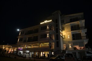 Un hotel de varios pisos con un letrero que dice 'Hotel River Retreat'.