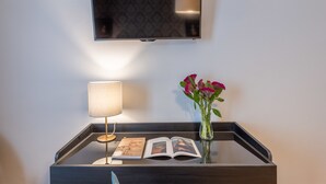 A bedside table with a lamp, a book, and a vase with flowers. - 3110 ArtHotel (Florence)