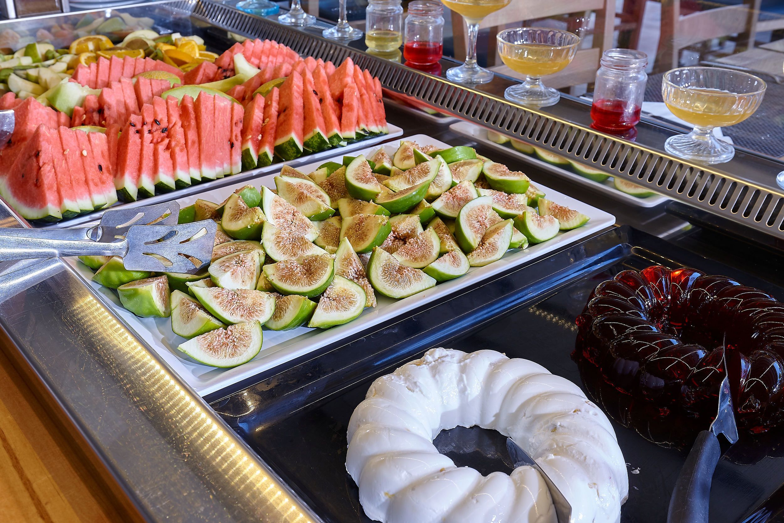 Un buffet proposant des tranches de pastèque, des figues et un dessert blanc.