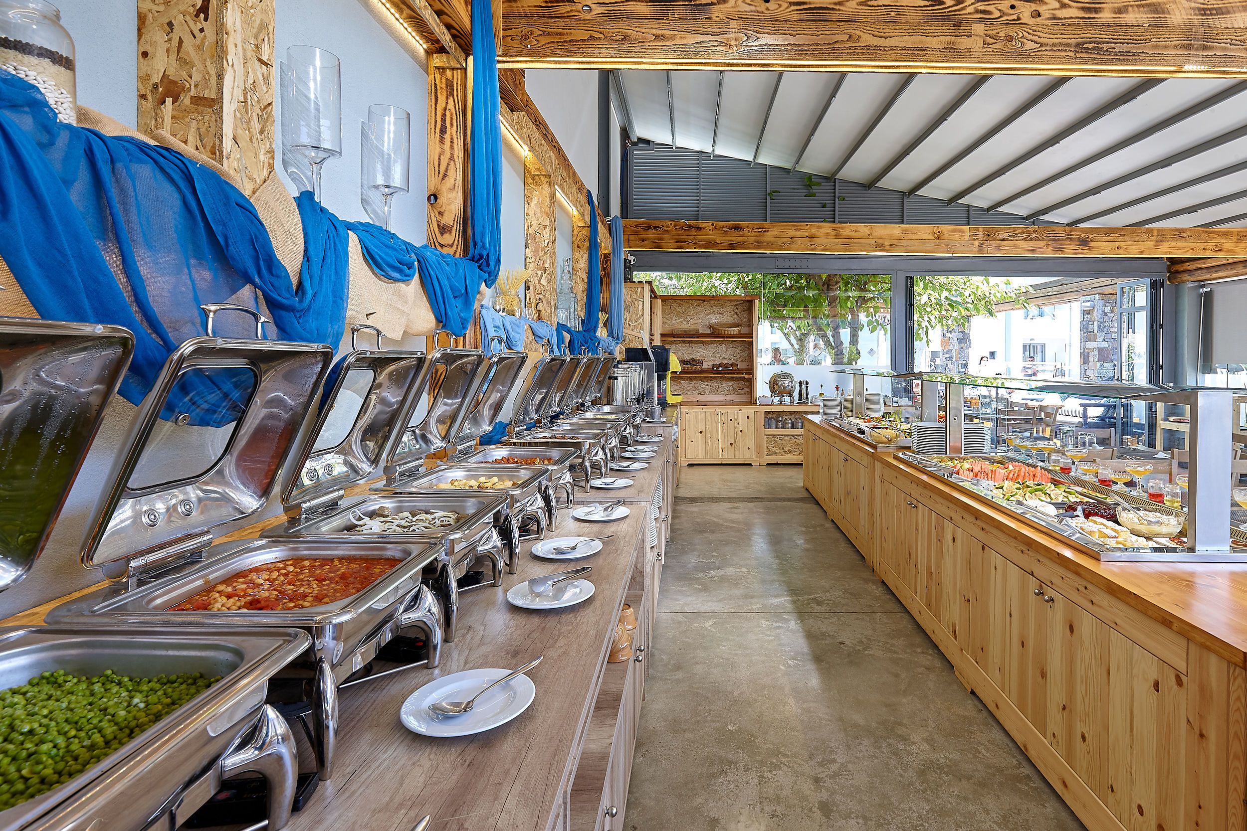 A buffet with multiple food stations and a view of the outside.