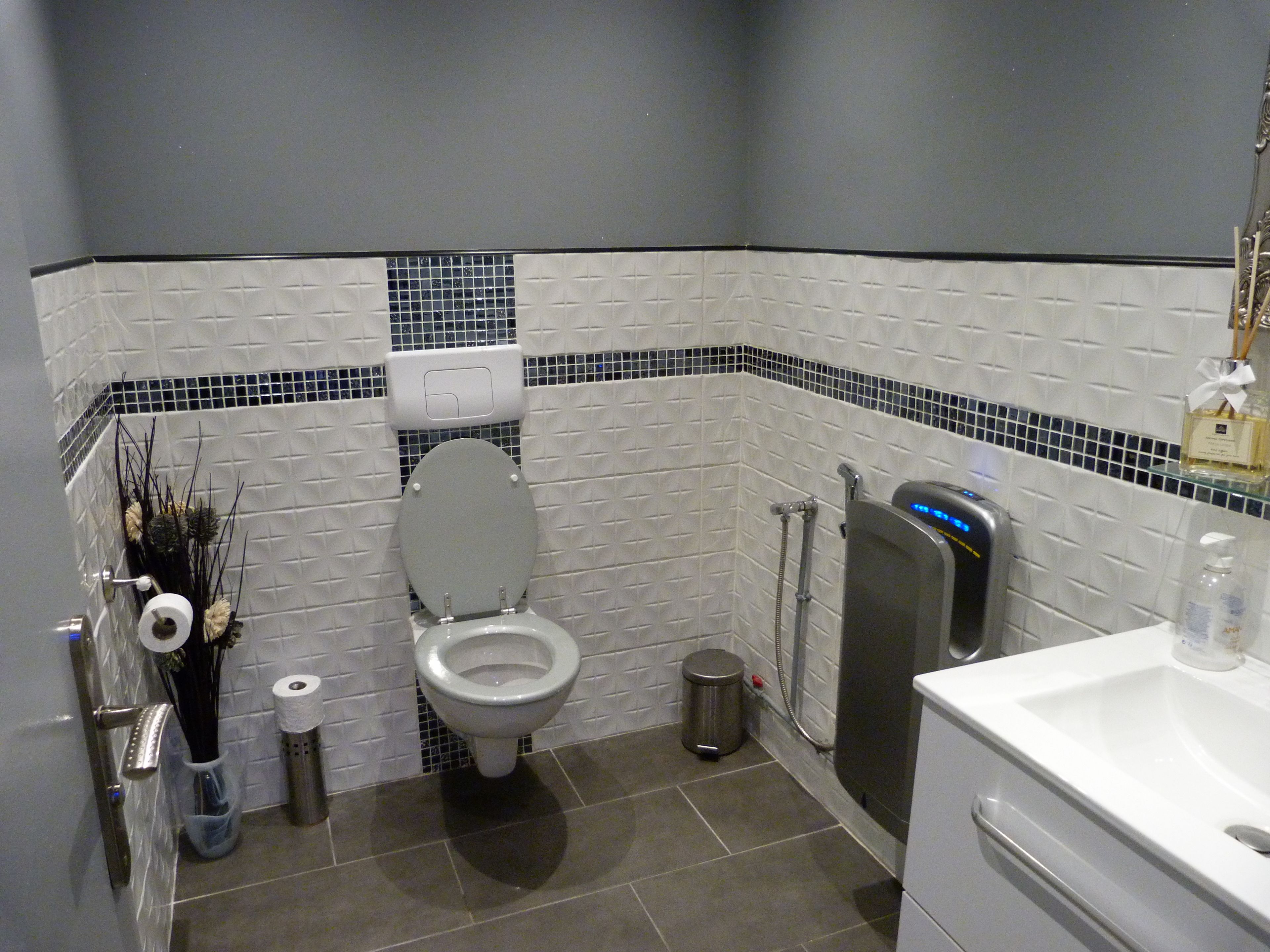 Une salle de bain équipée de toilettes, d’un bidet et d’un lavabo.