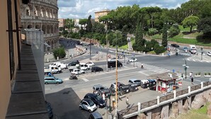 A view of the Colosseum with a busy street in the foreground. - Colosseo Rooms Imperial Rome (Rome)