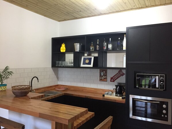 Exclusieve studio | Privékitchenette | Een koelkast, een magnetron, een kookplaat, kookgerei, borden en bestek