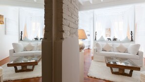 A modern living room with two white sofas, a glass coffee table, and a white rug. - Sweet Navona (Rome)