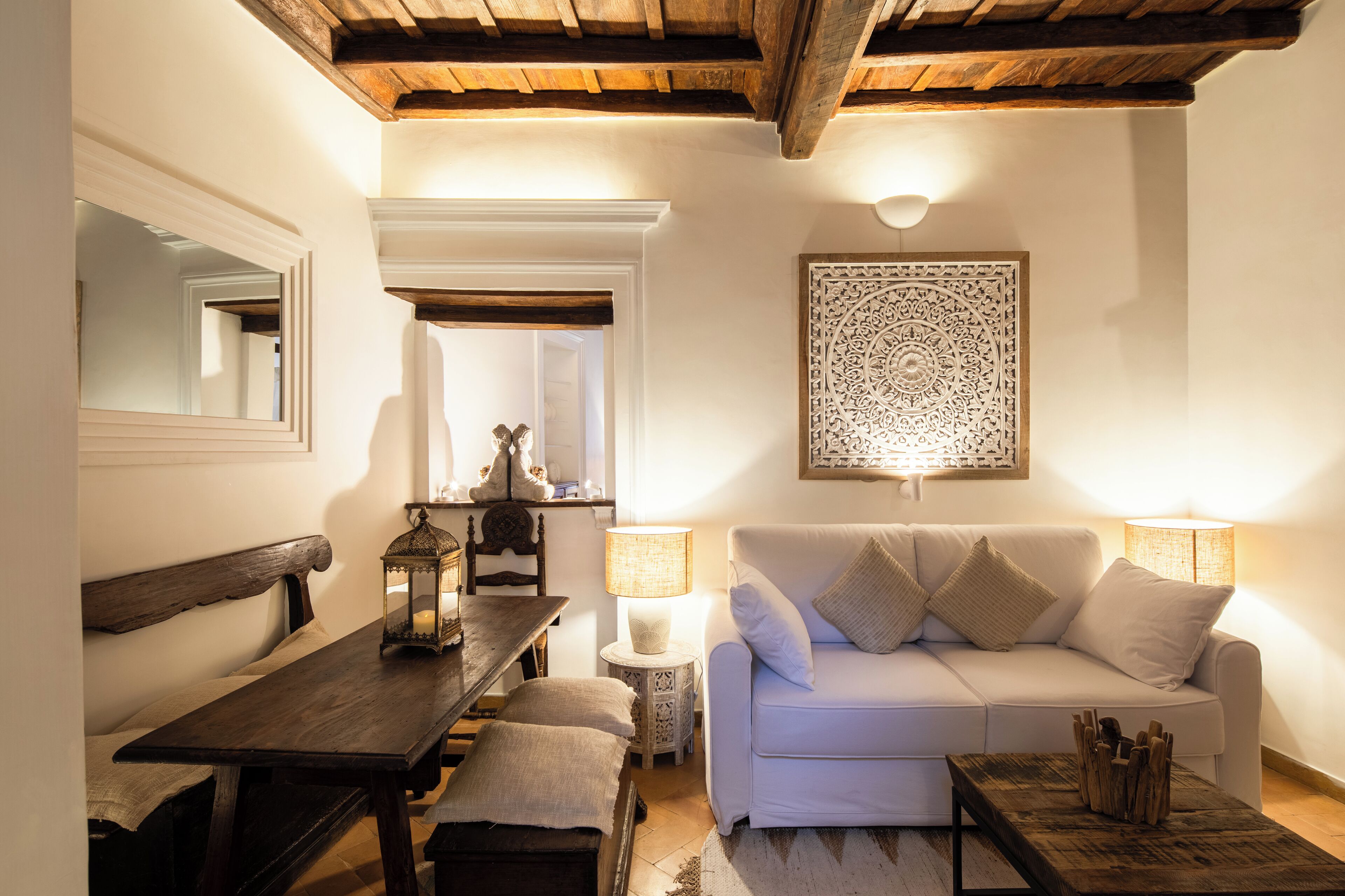 A cozy living room with a wooden bench, a white sofa, and a coffee table.