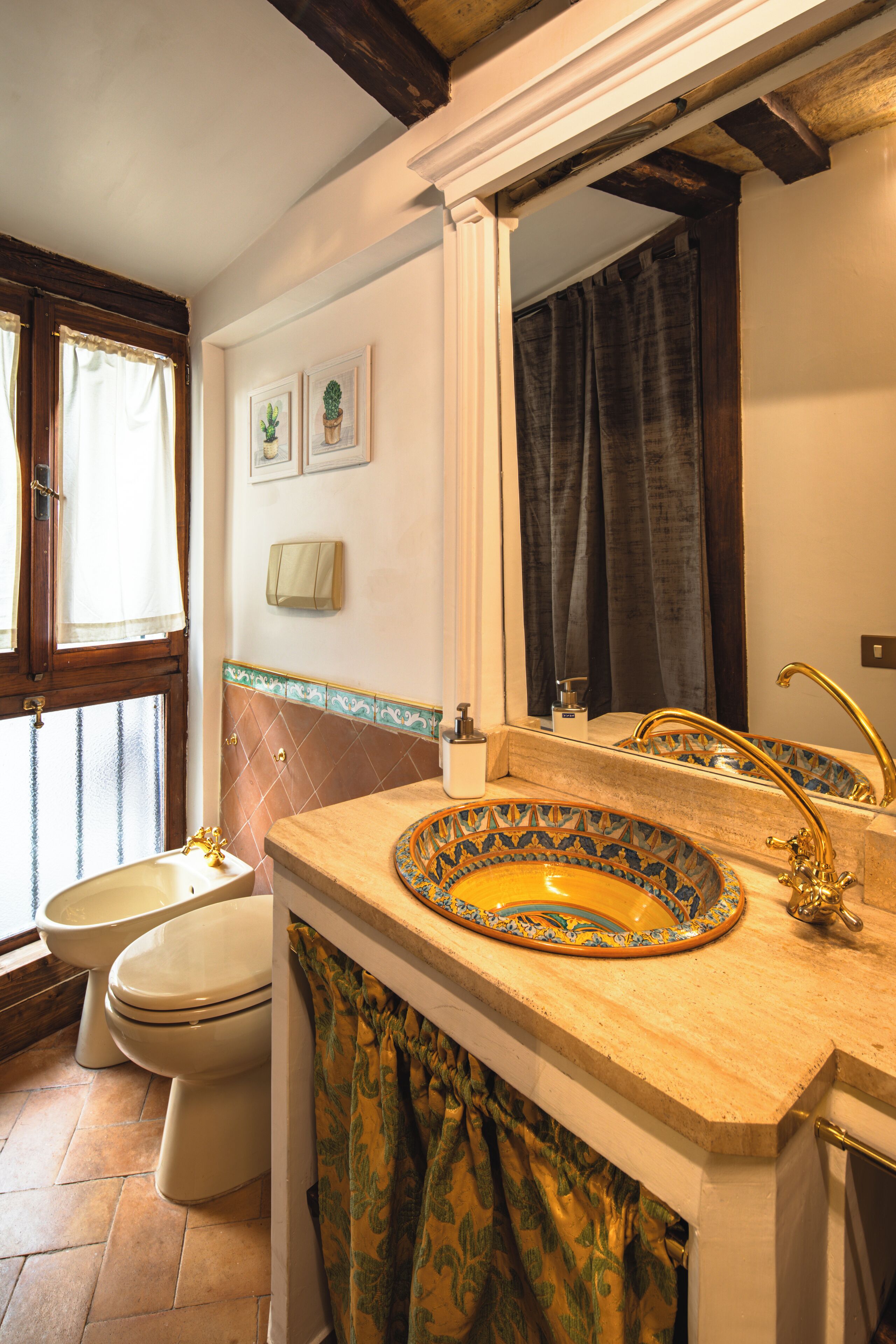 A bathroom with a sink, toilet, and window.