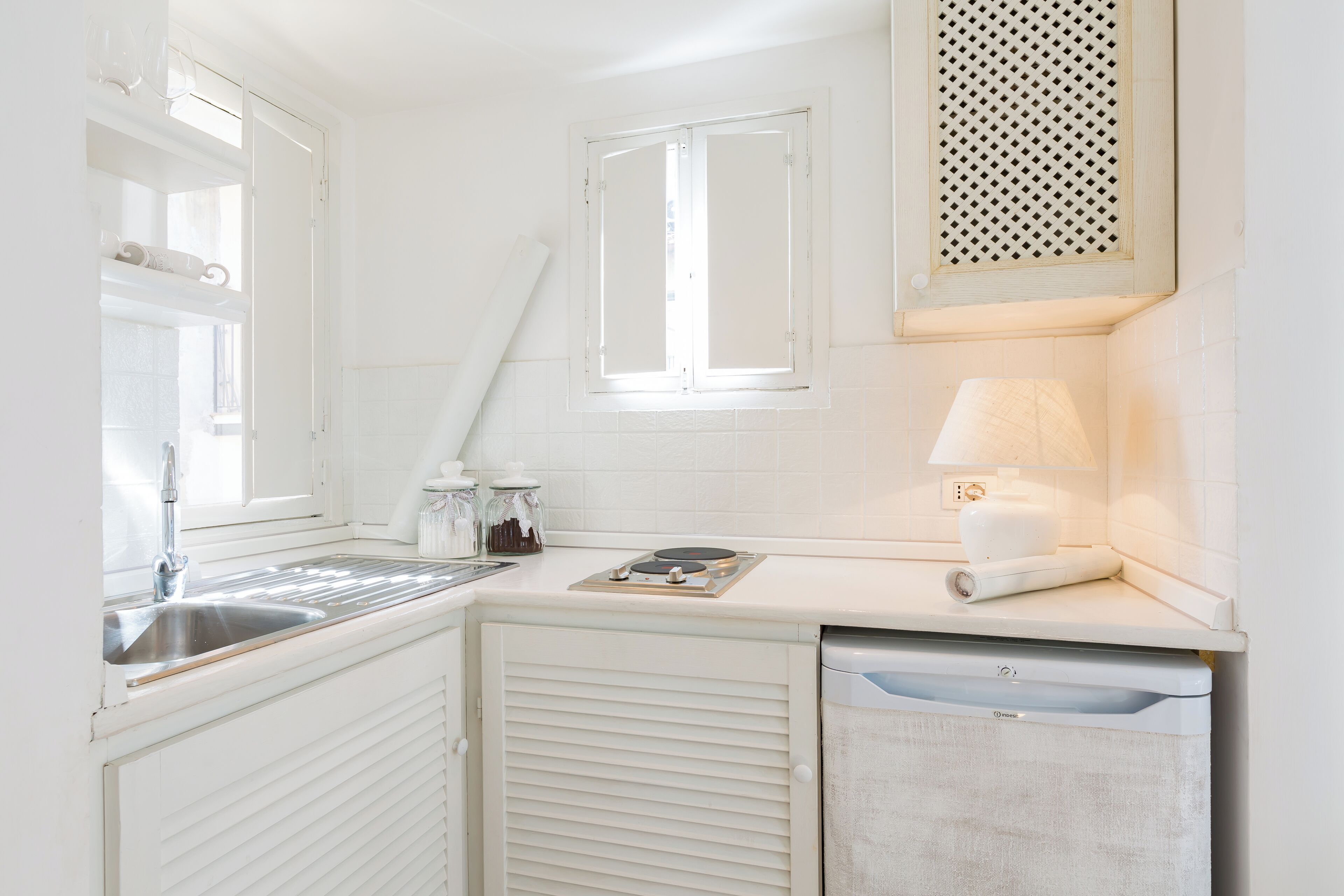 Una cucina compatta con lavandino, piano cottura e lavastoviglie.