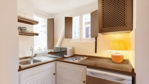 A compact kitchen with a microwave, toaster, and sink.