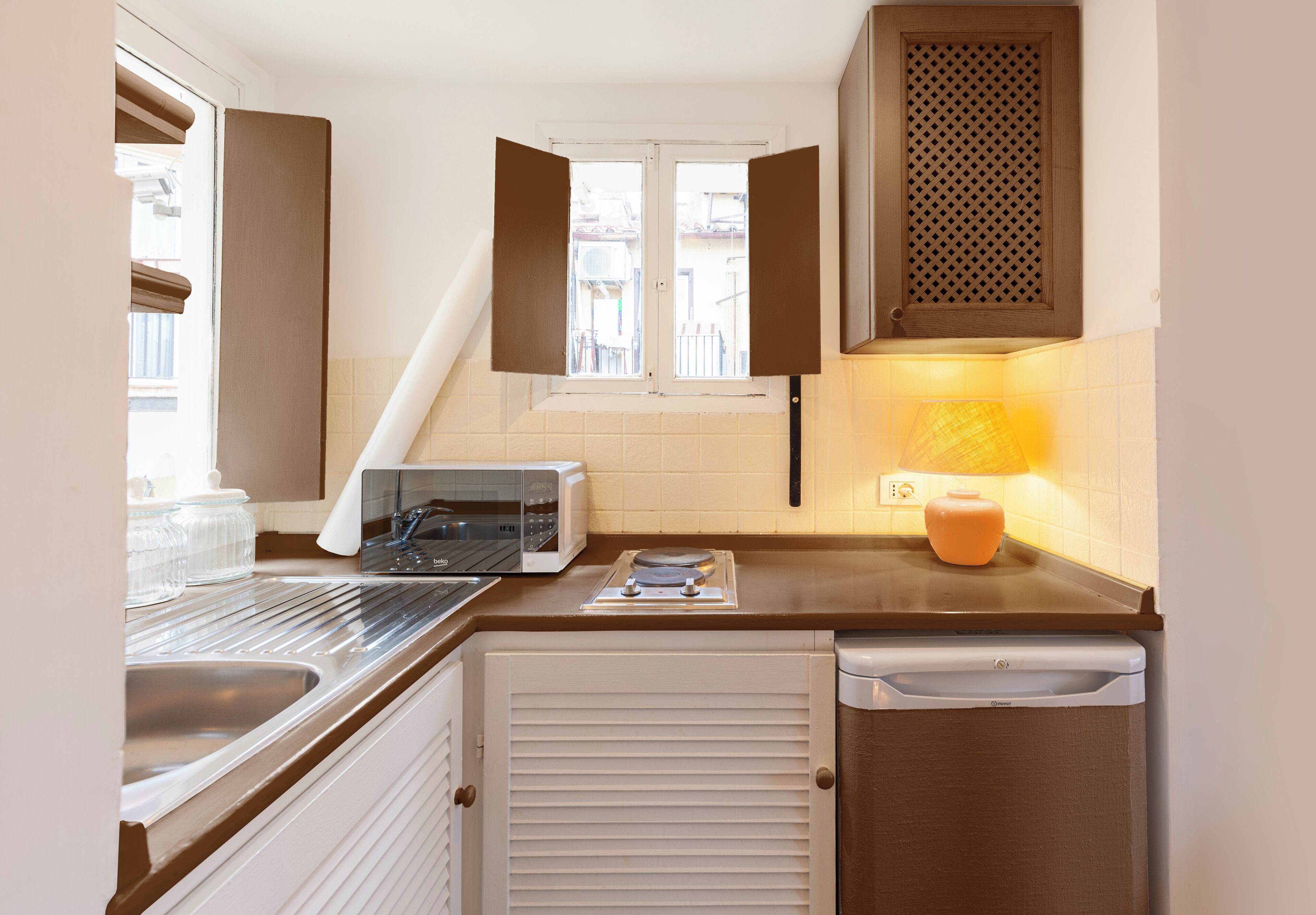 A compact kitchen with a microwave, toaster, and a small sink.