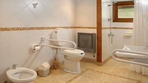 Een badkamer met toilet, bidet en wastafel.