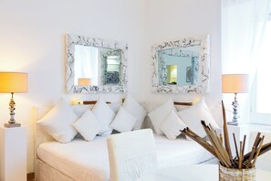 A hotel room with a bed, two bedside lamps, a mirror, and a vase with sticks. - Casa Ripetta (Rome)