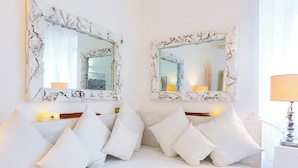 A hotel room with a white bed, white pillows, and two large mirrors with a white, textured frame. - Casa Ripetta (Rome)