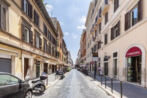 A cobblestone street lined with historic buildings, some with storefronts and signage. - Casa Ripetta (Rome)