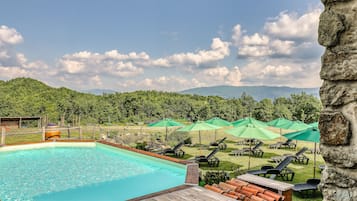 Una piscina al aire libre de temporada, sombrillas