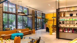 Eine moderne Lobby mit großen Fenstern, einem blauen Sofa, einer Holzbank und einer Dekoration.