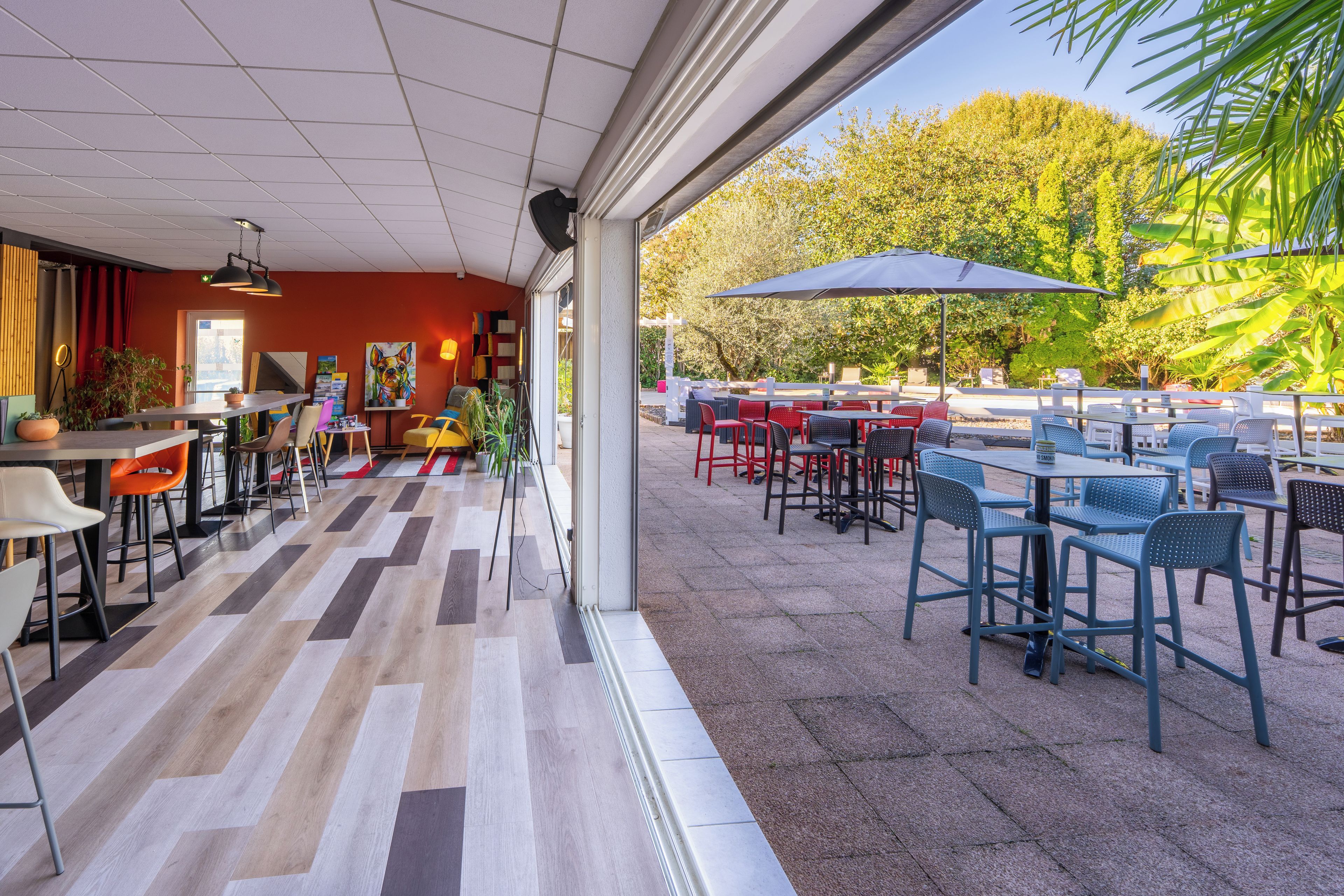 Un espace de restauration intérieur avec vue sur la terrasse extérieure.