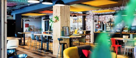 Un interior moderno con zona de bar, asientos y cocina a la vista.