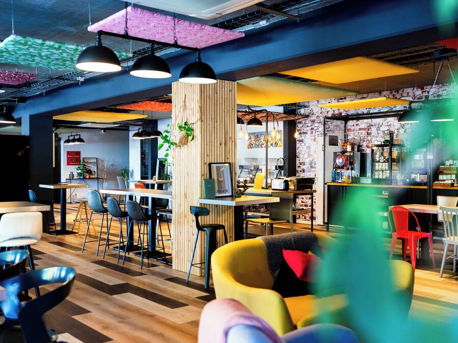 Un intérieur moderne avec un bar, des espaces pour s’asseoir et une cuisine ouverte.