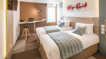 A hotel room with two beds, a desk, and a chair.