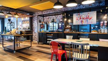 A modern cafe interior with a bar area, seating, and a mural on the wall.