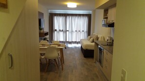 A compact living space with a dining area, kitchenette, and a bed. - Bariloche Downtown 3 I (San Carlos de Bariloche)