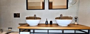 A bathroom with two sinks, a wooden vanity, and a mirror above the sinks. - Vatican Rome Suite (Rome)