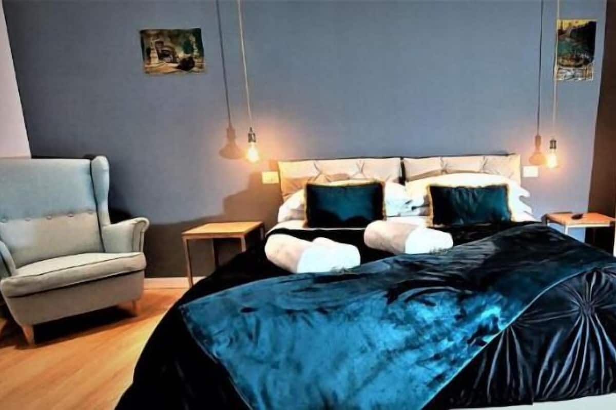 Una camera da letto con un letto, una sedia e un comodino.