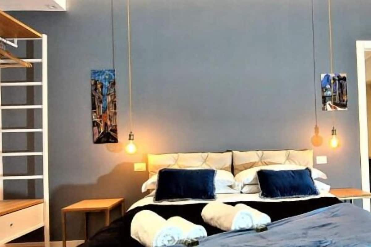Una camera da letto moderna con un letto, comodini e un armadio.