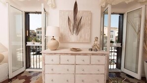 A room with a white dresser, a lamp, and a decorative piece on the wall. - Campo Home (Rome)