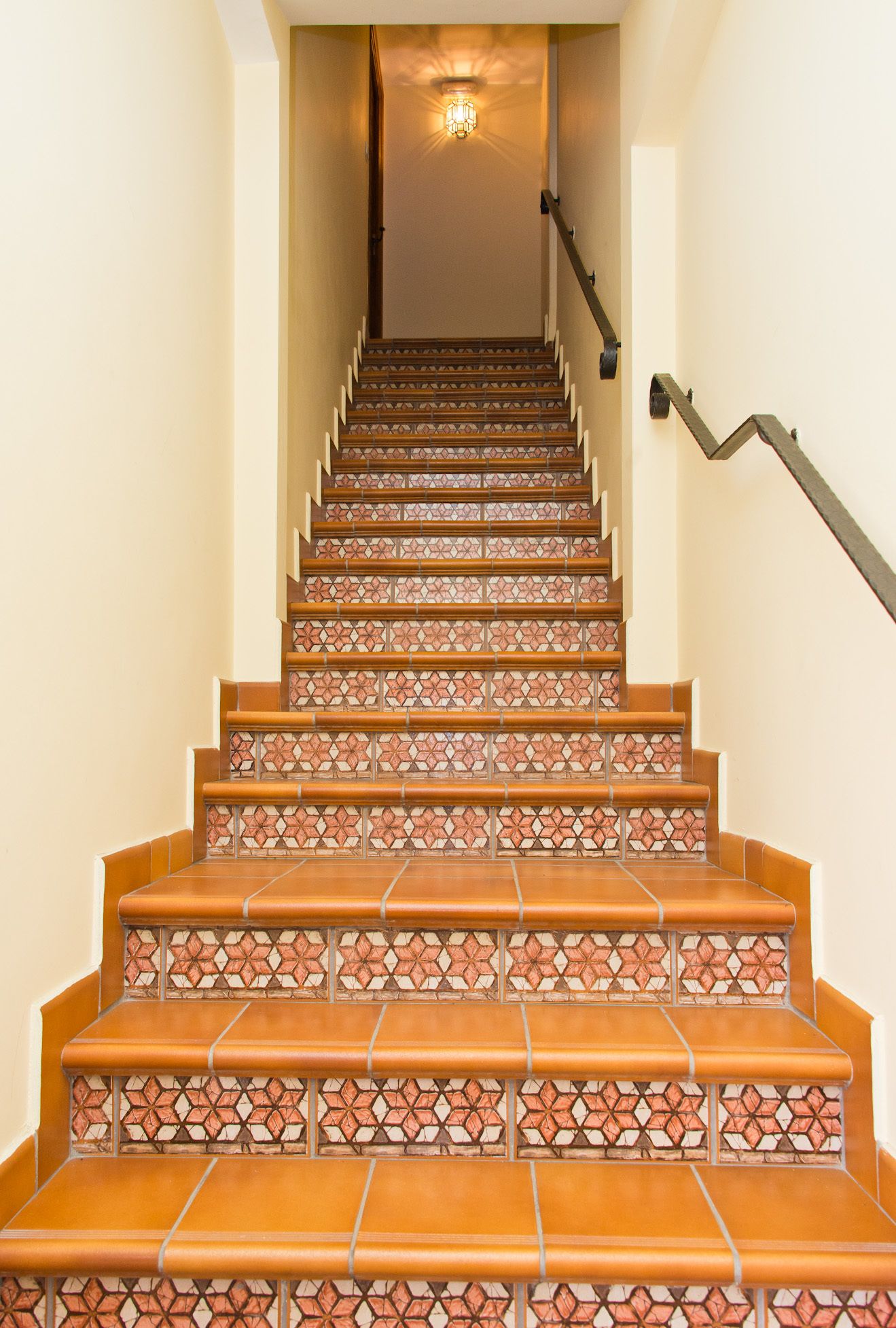 A staircase with patterned tiles and a handrail.