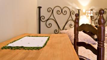 Una mesa de madera con un camino de mesa de encaje verde y un bloc blanco.