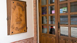 Een houten deur met een ruit, een plaquette met de tekst 'La Posada 2001 El Bayardo', en een Visa-logo op de ruit.